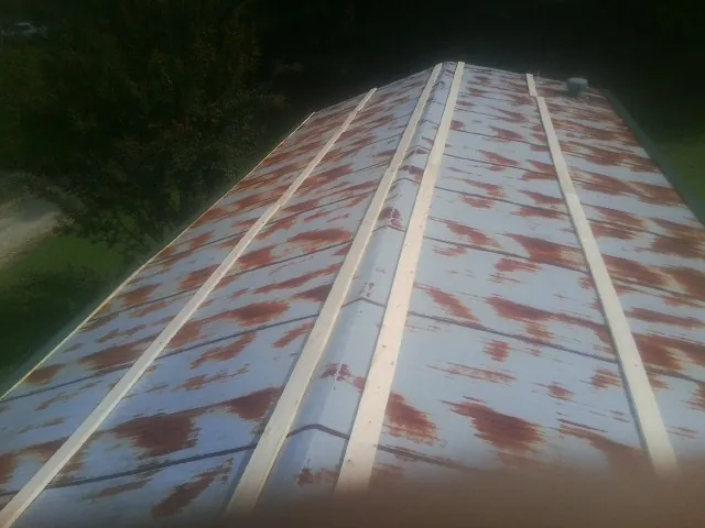 Rusted metal roof panels with new wood purlins before replacement — Storm Damage Roof Repair in Carrsville by Roofing Brothers