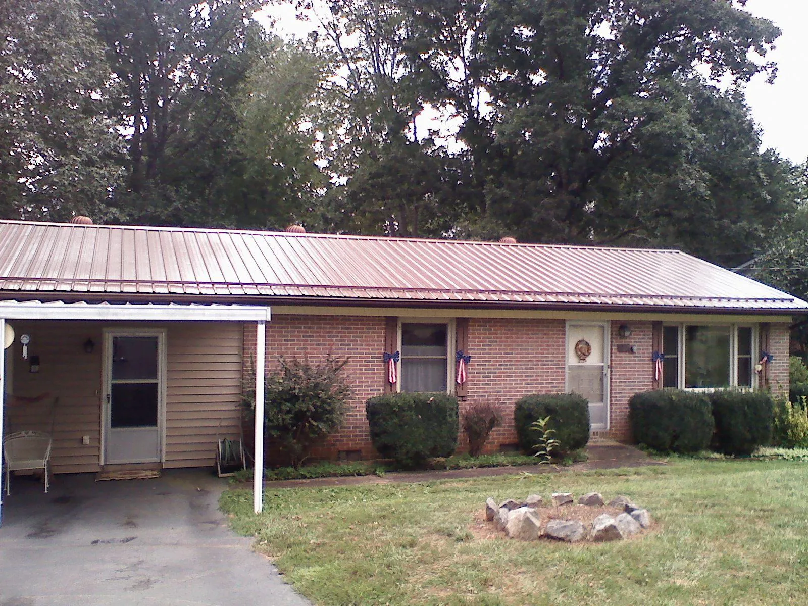 Bronze metal roof and carport on a brick ranch home — Roof Repair work by our crew in Carrsville