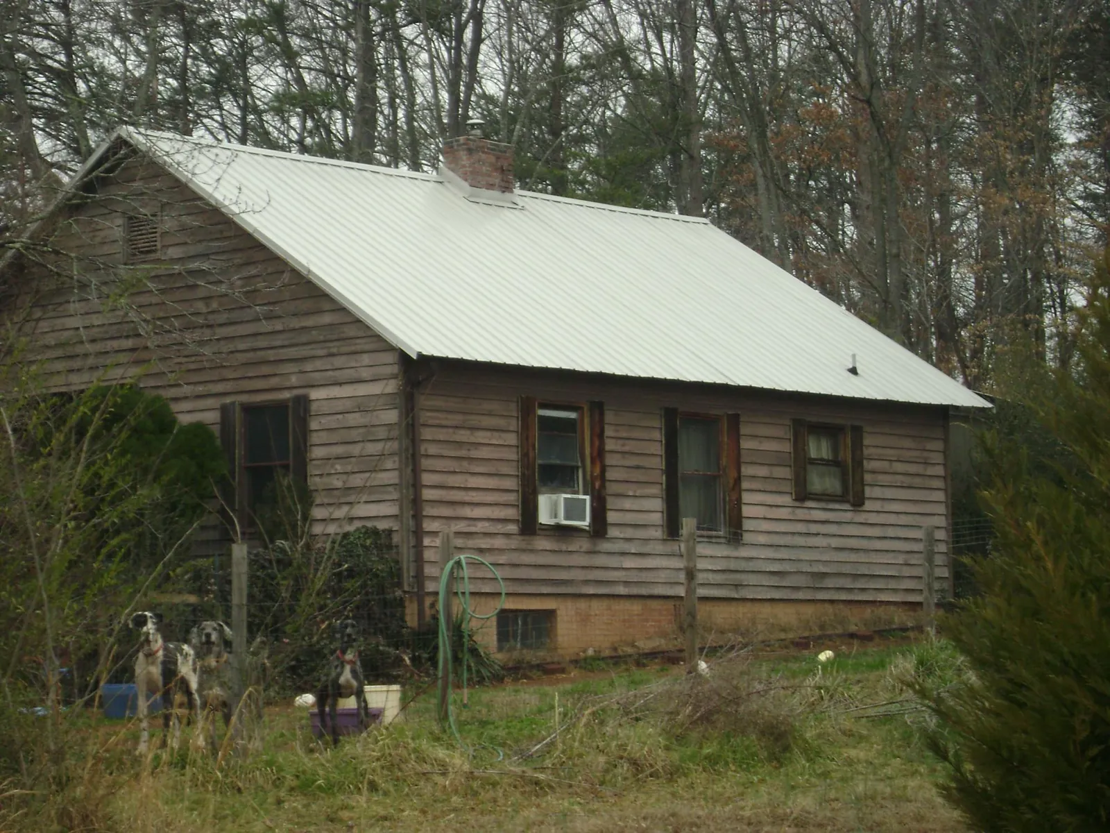 White metal roof on an old wood sided farmhouse, from a Metal Roof Installation job in Carrsville